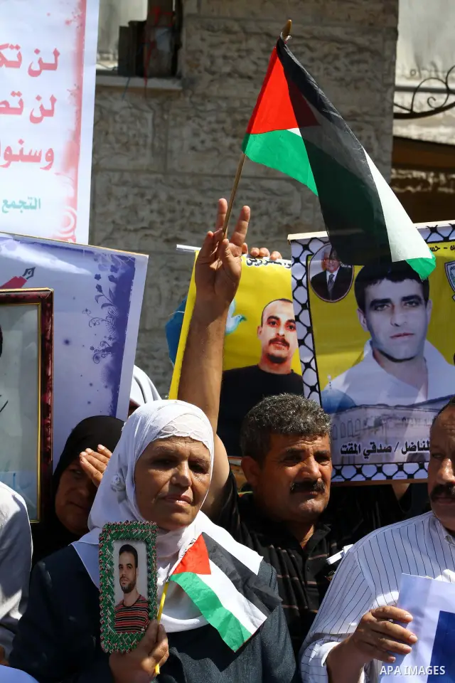 Palestinians hold pictures of their prisoned relatives in Israeli jails as they gather in a weekly activity calling for their liberty at the Red Cross headquarters in Gaza City on Sep. 19, 2011. About 7000 prisoners are...