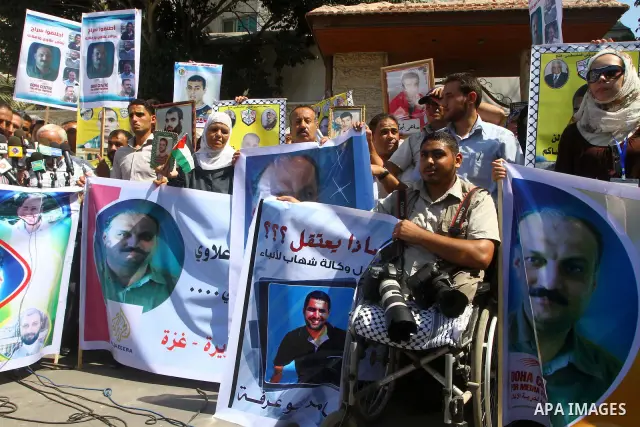Palestinians hold pictures of their prisoned relatives in Israeli jails as they gather in a weekly activity calling for their liberty at the Red Cross headquarters in Gaza City on Sep. 19, 2011. About 7000 prisoners are...