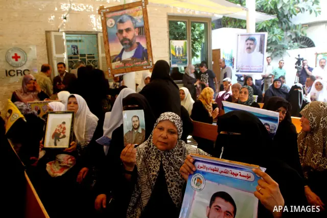 Palestinian women hold pictures of their prisoned relatives in Israeli jails as they gather in a weekly activity calling for their liberty at the Red Cross headquarters in Gaza City on Sep. 19, 2011. About 7000 prisoners...