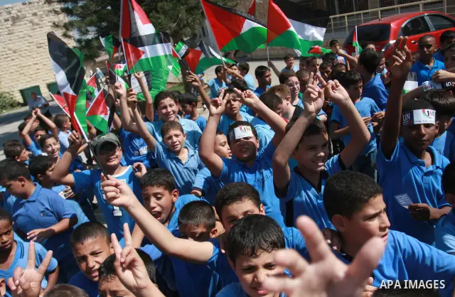 Palestinian schoolchildren hold their national flag during a rally in the West Bank city of Tulkarem, Monday, Sept. 19, 2011. Abbas is set to address the U.N. this week, planning to ask the world to recognize a Palestini...