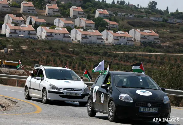 Palestinians wave their national flag during the launch of pro-Palestinian volunteer-based campaign which will intervene and respond to cases of violence towards Palestinians by Jewish settlers in the West Bank, in the W...