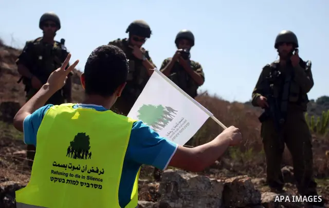 Israeli soldiers stand guard in front of members pro-Palestinian volunteer-based campaign which will intervene and respond to cases of violence towards Palestinians by Jewish settlers in the West Bank, in the West Bank v...