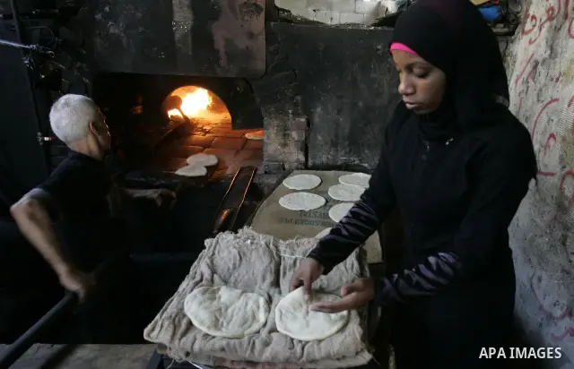 A Palestinian man bakes bread in a traditional mud oven in Rafah refugee camp, southern Gaza Strip on September 19, 2011. A diplomatic showdown looms at the United Nations this month when Palestinian President Mahmoud Ab...