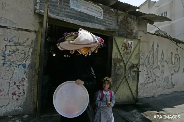 A Palestinian woman bakes bread in a traditional mud oven in Rafah refugee camp, southern Gaza Strip on September 19, 2011. A diplomatic showdown looms at the United Nations this month when Palestinian President Mahmoud...