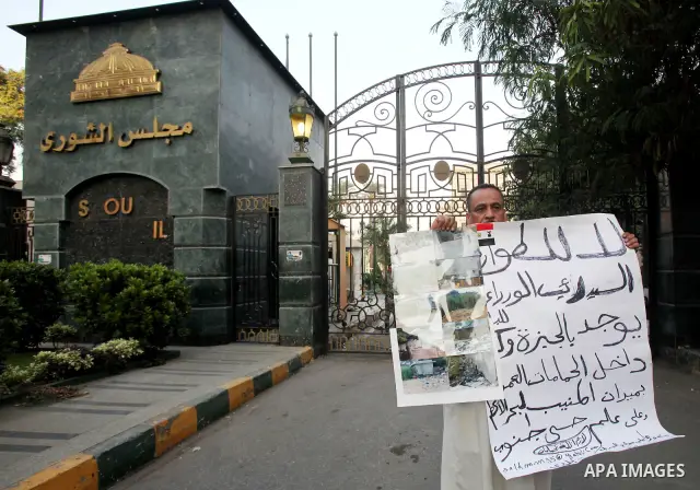 An Egyptian man holds slogan in a protest against the reassertion of the Emergency Law in the wake of the attack on the Israeli Embassy on 9 September. Egyptian activists marching through the street holding signs and cha...