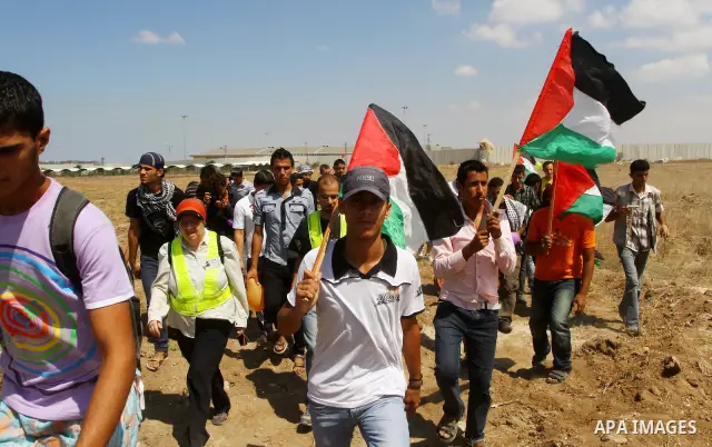 Palestinian and foreign activists take part in a rally in support of the Palestinian UN bid for statehood near the fence separating Israel from the Gaza Strip, in Beit Hanun, on September 20, 2011. The Palestinians are p...