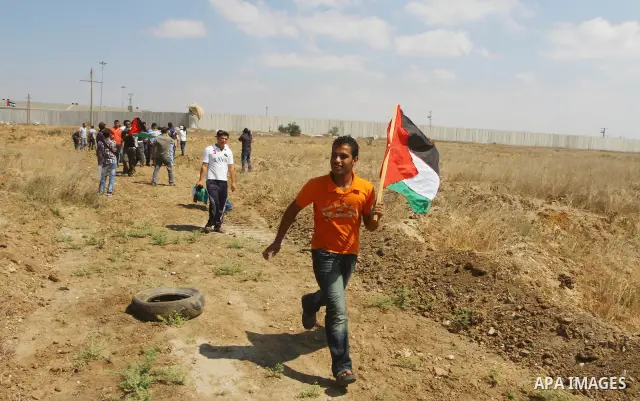 Palestinian and foreign activists take part in a rally in support of the Palestinian UN bid for statehood near the fence separating Israel from the Gaza Strip, in Beit Hanun, on September 20, 2011. The Palestinians are p...