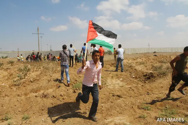 Palestinian and foreign activists take part in a rally in support of the Palestinian UN bid for statehood near the fence separating Israel from the Gaza Strip, in Beit Hanun, on September 20, 2011. The Palestinians are p...
