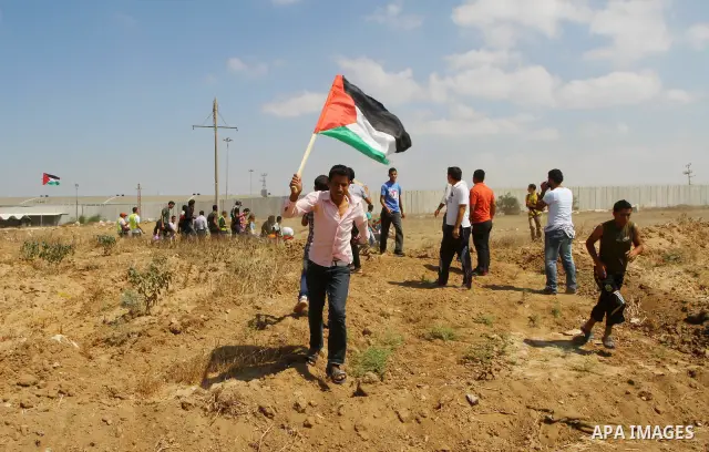 Palestinian and foreign activists take part in a rally in support of the Palestinian UN bid for statehood near the fence separating Israel from the Gaza Strip, in Beit Hanun, on September 20, 2011. The Palestinians are p...