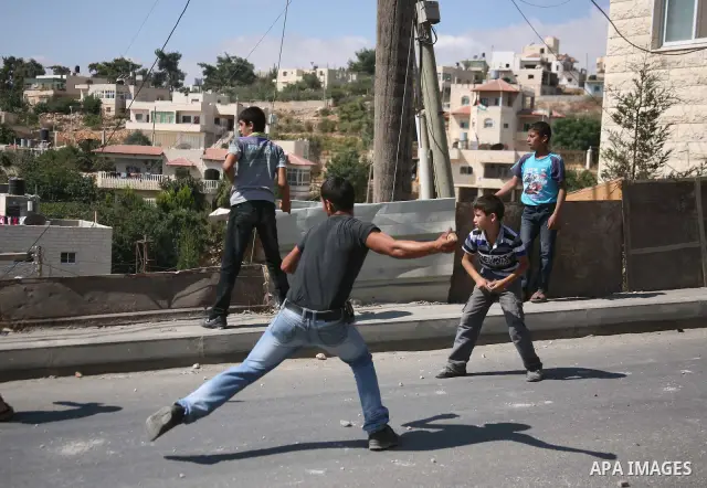 Palestinian youths throw stones towards Israeli soldiers during a protest in the West Bank village of Beit Omar, near Hebron on 20 September 2011. President Mahmoud Abbas intends to make a bid on 23 September for United...