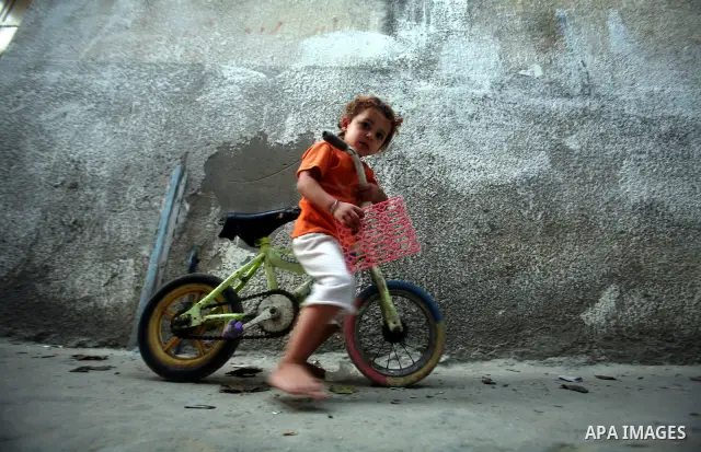 A Palestinian child plays in front of their house in the Jabaliya refugee camp in the northern area of the Gaza Strip on 20 September 2011. A diplomatic showdown looms at the United Nations this month when Palestinian Pr...