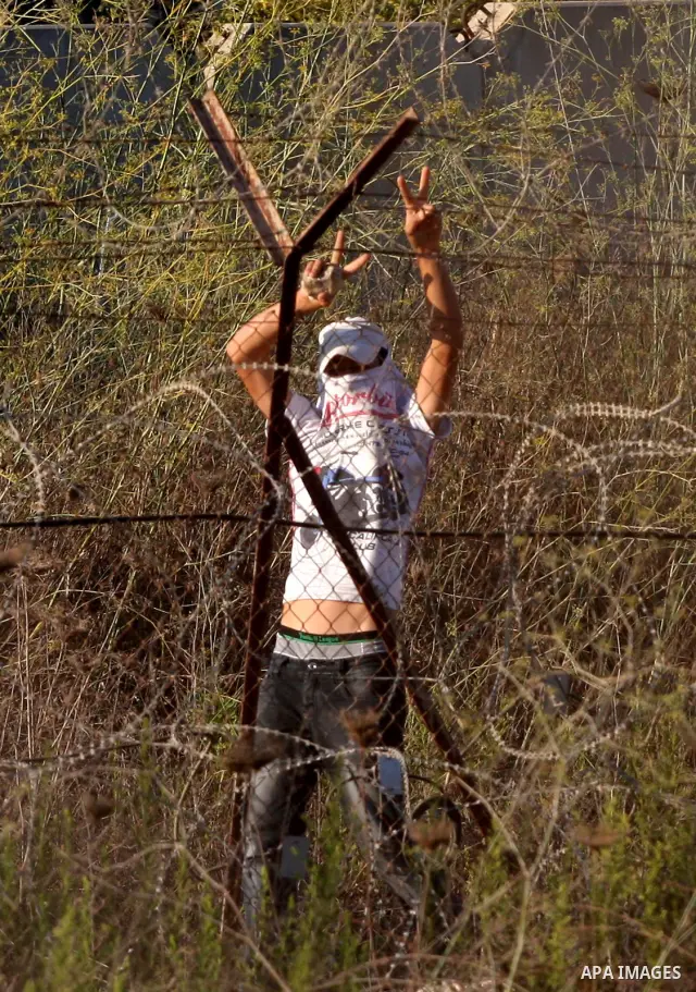 Masked Jewish settler boys from the Israeli West bank settlement of Bet El, throw stones at Palestinians Near the refugee camp of Jalazoun in the West Bank city of Ramallah on September 20, 2011. Reports state that Pales...
