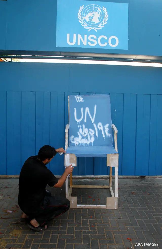 Palestinian carpenter Mustafa Masoud, 24, takes a chair symbolizing the Palestinian statehood bid from his house to be placed in front of the UN offices in Gaza city, Wednesday, Sept. 21, 2011. Writing in Arabic reads "P...