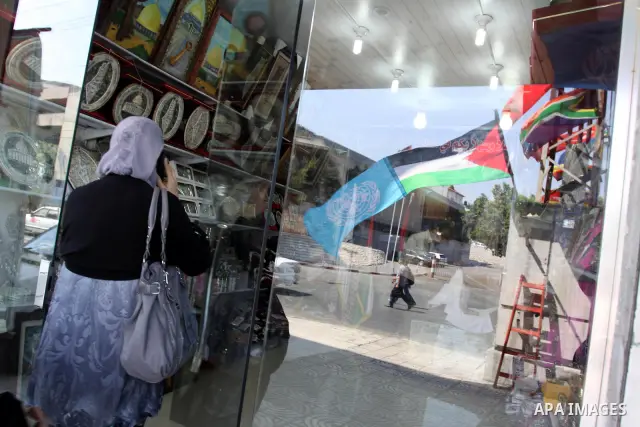 A Palestinian and UN flag flutter outside a souvenirs shop in Gaza City in support of Palestinian President Mahmoud Abbas' bid for statehood cin the United Nations on September 21, 2011. Abbas plans on Friday to submit a...