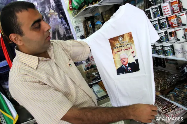 A Palestinian vendor displays a picture of the Palestinian President Mahmoud Abbas (Abu Mazen) on Shirts, in support of Palestinian President Mahmoud Abbas' bid for statehood recognition in the United Nations on Septembe...