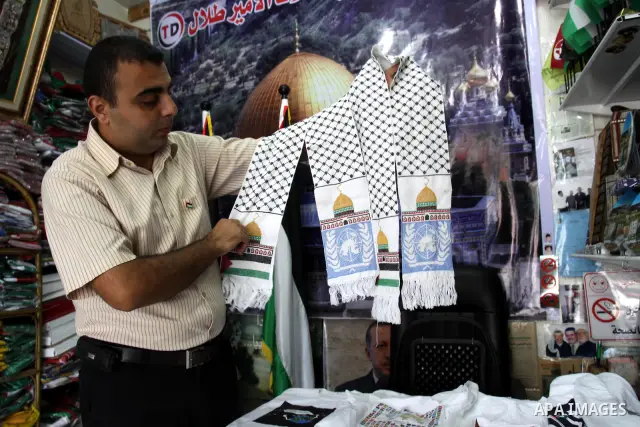 A Palestinian vendor displaysa Scarf for the Jerusalem city on a shirts, in support of Palestinian President Mahmoud Abbas' bid for statehood recognition in the United Nations on September 21, 2011. Abbas plans on Friday...