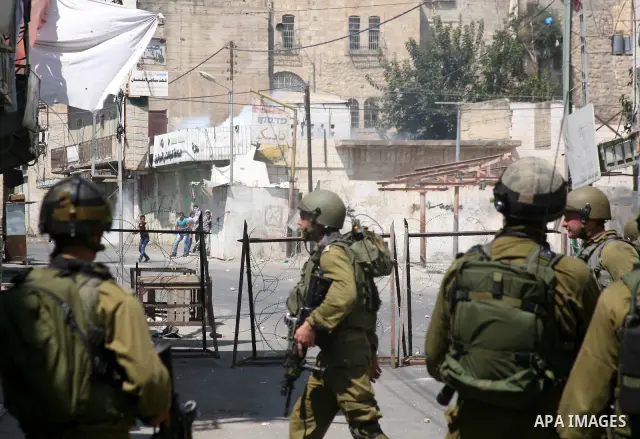 Palestinian youths throw stones towards Israeli soldiers during a protest in the West Bank city of Hebron 21 September 2011, as Palestinian president Mahmud Abbas prepares to submit a formal request for Palestine to beco...