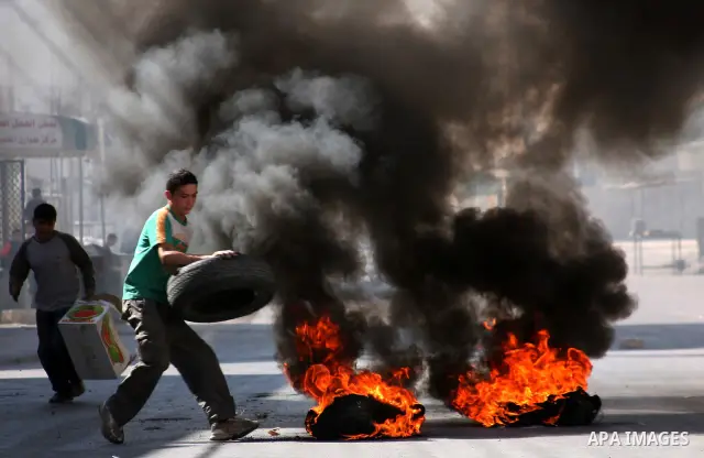 Palestinian youths burn tires during clashes with Israeli soldiers following a protest in the West Bank city of Hebron 21 September 2011, as Palestinian president Mahmud Abbas prepares to submit a formal request for Pale...