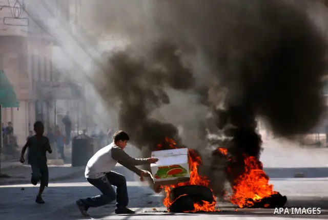Palestinian youths burn tires during clashes with Israeli soldiers following a protest in the West Bank city of Hebron 21 September 2011, as Palestinian president Mahmud Abbas prepares to submit a formal request for Pale...