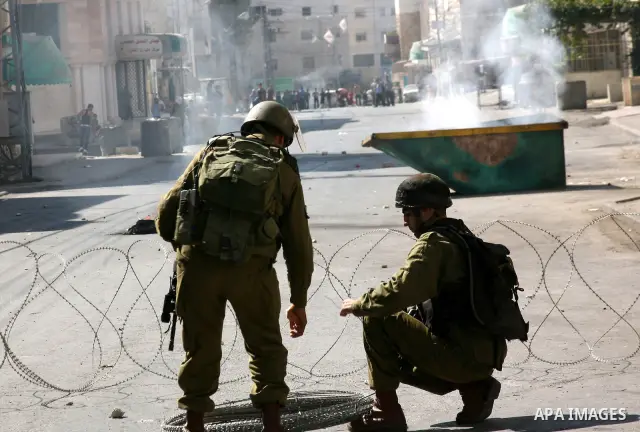 Israeli soldiers take position during clashes with Palestinians following a protest in the West Bank city of Hebron 21 September 2011, as Palestinian president Mahmud Abbas prepares to submit a formal request for Palesti...