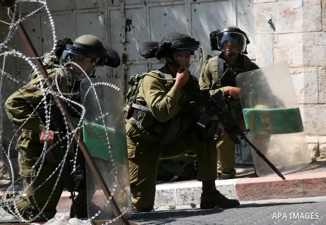 Israeli soldiers take position during clashes with Palestinians following a protest in the West Bank city of Hebron 21 September 2011, as Palestinian president Mahmud Abbas prepares to submit a formal request for Palesti...