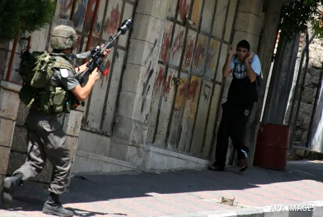 An Israeli soldier fires tear gas canister during clashes with Palestinians following a protest in the West Bank city of Hebron 21 September 2011, as Palestinian president Mahmud Abbas prepares to submit a formal request...