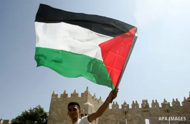 A Palestinian man waves his national flag during a protest against US interference in the Palestinian bid for statehood recognition at the United Nations on September 21, 2011 in Jerusalem's Damascus Gate. Palestinians a...