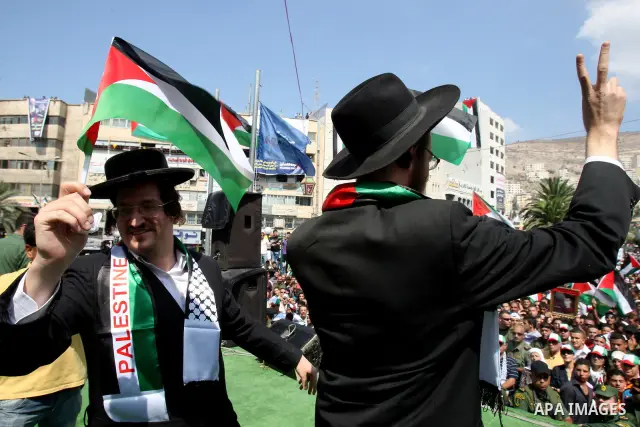 Members of Neturei Karta, a small faction of ultra-Orthodox Jews who oppose Israel's existence,wave Palestinian flags to express support for the Palestinian bid for statehood recognition at the United Nations as thousand...
