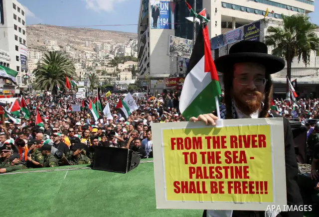 Members of Neturei Karta, a small faction of ultra-Orthodox Jews who oppose Israel's existence, hold placards to express support for the Palestinian bid for statehood recognition at the United Nations as thousands of Pal...
