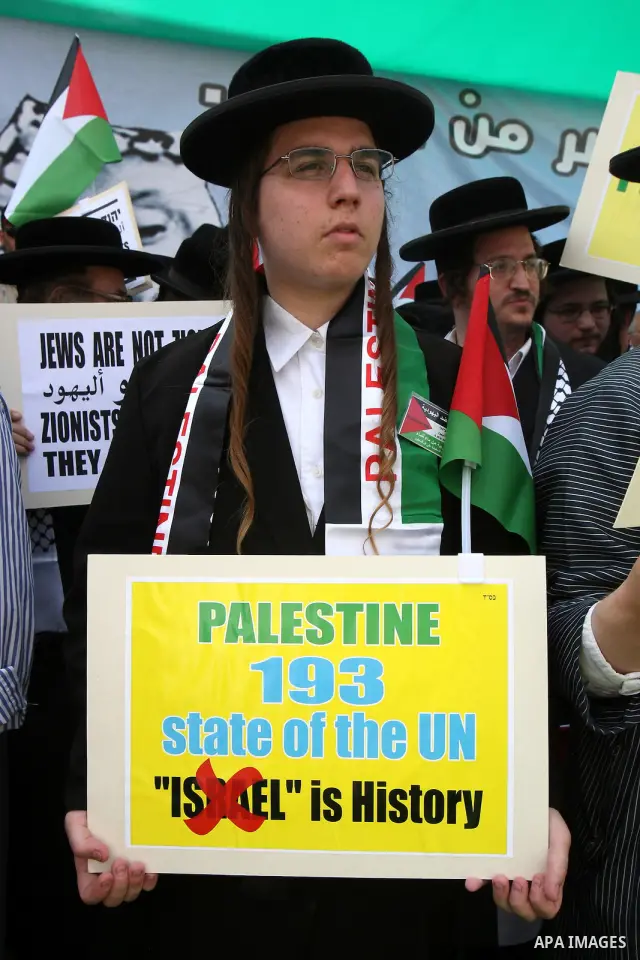 Members of Neturei Karta, a small faction of ultra-Orthodox Jews who oppose Israel's existence, hold placards to express support for the Palestinian bid for statehood recognition at the United Nations as thousands of Pal...