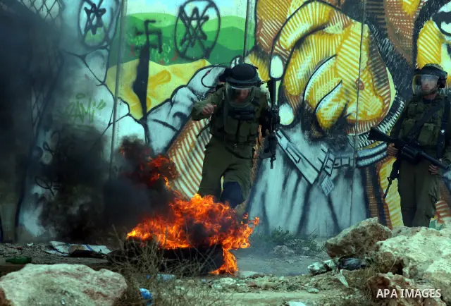 Israeli soldiers run to take position during clashes with Palestinian protesters at the Qalandia checkpoint between the West Bank city of Ramallah and Jerusalem, Wednesday, Sept. 21, 2011. Palestinians clashed with Israe...