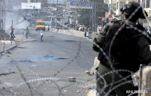 Palestinian protesters throw stones at Israeli soldiers during clashes at the Qalandia checkpoint between the West Bank city of Ramallah and Jerusalem, Wednesday, Sept. 21, 2011. Palestinians clashed with Israeli securit...