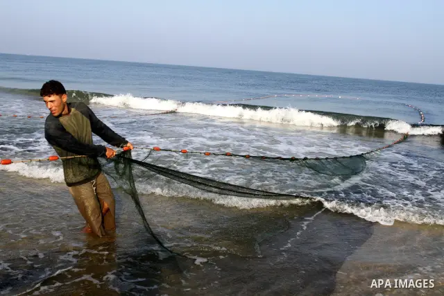 Palestinian fishermen pull their nets at the beach of Gaza city on Sep. 22, 2011. Palestinians hoped that the blockade is lifted from the sea, and setting "Palestine state 194", representing their hope to become the 194t...