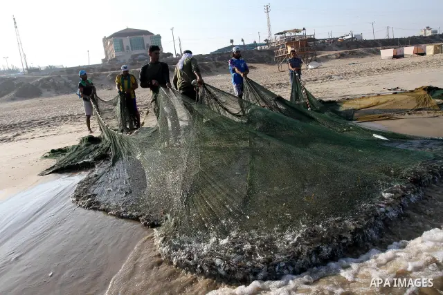Palestinian fishermen pull their nets at the beach of Gaza city on Sep. 22, 2011. Palestinians hoped that the blockade is lifted from the sea, and setting "Palestine state 194", representing their hope to become the 194t...