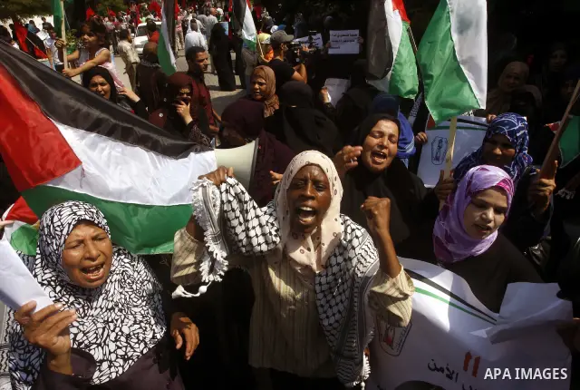 Palestinian women chant slogans and wave their national flag during a demonstration in support of Palestinian leader Mahmud Abbas' bid for statehood recognition at the United Nations on September 22, 2011 in Gaza City. P...