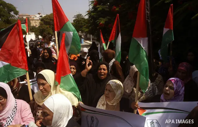 Palestinian women chant slogans and wave their national flag during a demonstration in support of Palestinian leader Mahmud Abbas' bid for statehood recognition at the United Nations on September 22, 2011 in Gaza City. P...