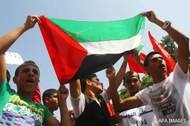 Palestinian men chant slogans and wave their national flag during a demonstration in support of Palestinian leader Mahmud Abbas' bid for statehood recognition at the United Nations on September 22, 2011 in Gaza City. Pho...