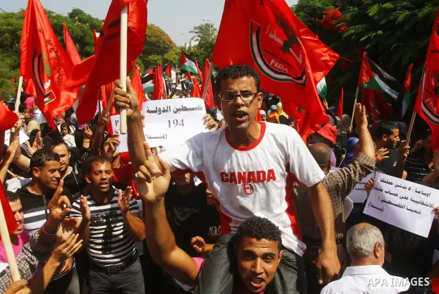 Palestinian men chant slogans and wave their national flag during a demonstration in support of Palestinian leader Mahmud Abbas' bid for statehood recognition at the United Nations on September 22, 2011 in Gaza City. Pho...