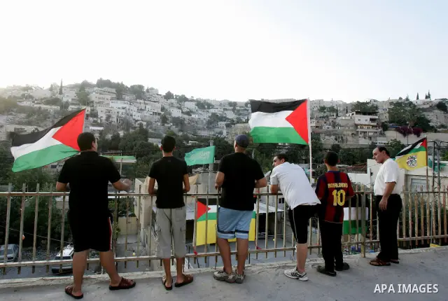 Palestinians wave their national flag at a street on September 22, 2011 in the east Jerusalem neighborhood of Silwan. Palestinians are preparing to submit a formal request to become the 194th member of the United Nations...