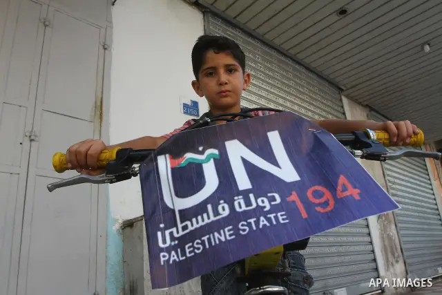 A Palestinian boy rides a bicycle decorated with a sign supporting the Palestinians' bid in the United Nations for statehood recognition, on September 23, 2011 in Gaza City. Palestinian president Mahmud Abbas will presen...