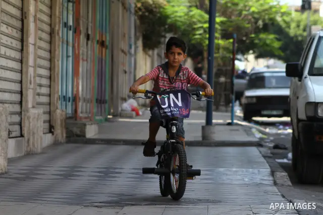 A Palestinian boy rides a bicycle decorated with a sign supporting the Palestinians' bid in the United Nations for statehood recognition, on September 23, 2011 in Gaza City. Palestinian president Mahmud Abbas will presen...