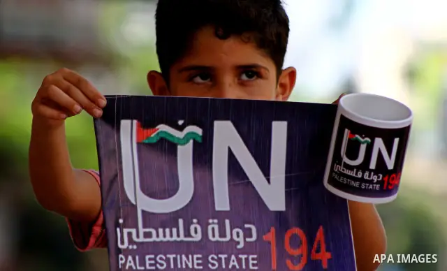 A Palestinian boy holds a coffee mug in Gaza City as part of the campaign promoting the Palestinians' bid at the United Nations for statehood recognition, on September 23, 2011. Palestinian president Mahmud Abbas will pr...