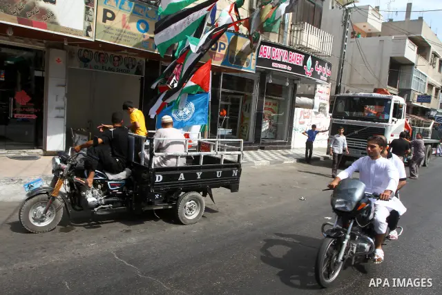 A Palestinian rides a motorcycle past a souvenir shop in Gaza City September 21, 2011. Palestinian President Mahmoud Abbas plans on Friday to submit an application for full U.N. membership for the state of Palestine base...