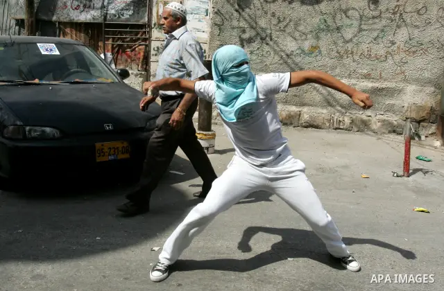 A Palestinian youth throws stones toward Israeli border police during clashes in the east Jerusalem neighborhood of Ras al-Amud on September 23, 2011, just hours before their president, Mahmoud Abbas, was to deliver his...