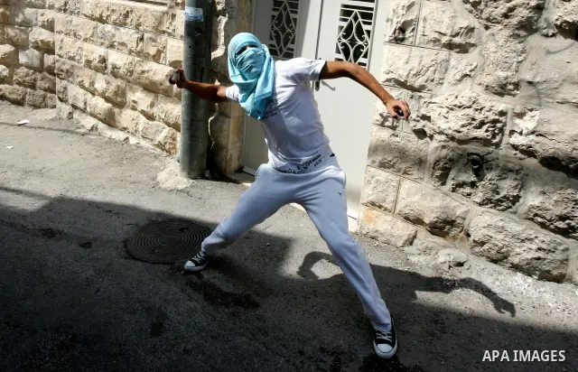 A Palestinian youth throws stones toward Israeli border police during clashes in the east Jerusalem neighborhood of Ras al-Amud on September 23, 2011, just hours before their president, Mahmoud Abbas, was to deliver his...