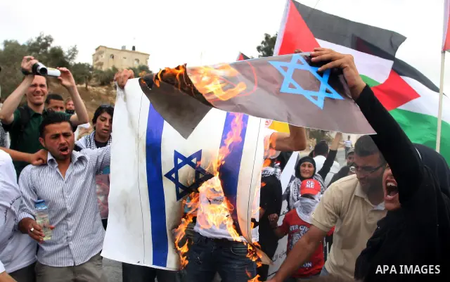 Palestinian protesters burn an Israeli flag and a poster depicting U.S. President Barack Obama at a weekly protest in the West Bank village of Nabi Saleh, near Ramallah September 23, 2011. Israeli security forces were on...