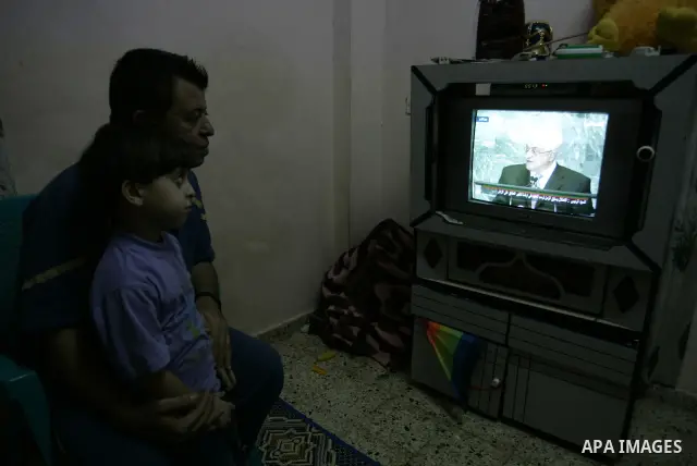 Palestinians watch the President Mahmoud Abbas on TV as he addresses the General Assembly of the United Nations at their house in the Rafah refugee camp, southern Gaza Strip Friday, Sept. 23, 2011. Photo by Abed Rahim Kh...
