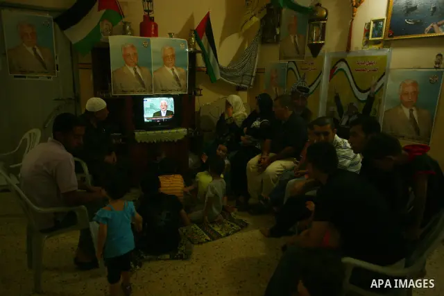 A Palestinian family watches as their president Mahmud Abbas addresses the General Assembly of the United Nations, in Gaza City on September 23, 2011 where he called on the UN to admit a state of Palestine as a full memb...