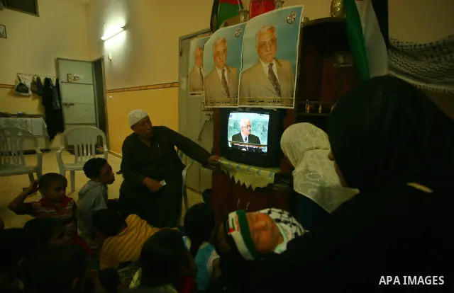 A Palestinian family watches as their president Mahmud Abbas addresses the General Assembly of the United Nations, in Gaza City on September 23, 2011 where he called on the UN to admit a state of Palestine as a full memb...