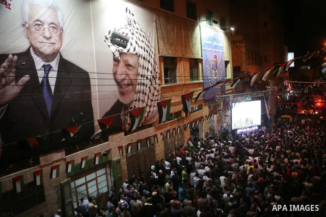 Palestinians watch their President Mahmoud Abbas on TV as he delivers his speech at the General Assembly of the United Nations, in the West Bank city of Hebron, Friday, Sept. 23, 2011. Photo by Mamoun Wazwaz